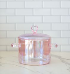 a pink crock pot sitting on top of a counter next to a white brick wall