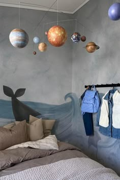 a bedroom with an ocean themed wallpaper and space theme on the walls is shown