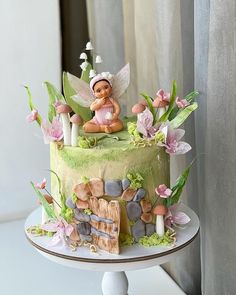 there is a cake decorated with flowers and a fairy figurine