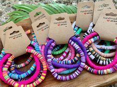 several different colored bracelets sitting on top of a wooden table