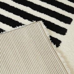 two pieces of black and white rugs laying next to each other on the floor