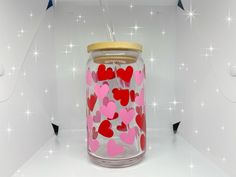 a glass jar with hearts painted on it