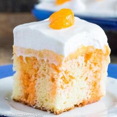 a piece of cake with white frosting and oranges on top sits on a plate