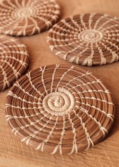 four woven coasters sitting on top of a wooden table