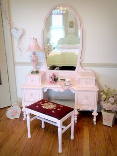 a white vanity table with a mirror and stool