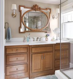 a bathroom with wooden cabinets and a large mirror