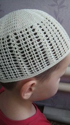 a young boy wearing a white knitted hat