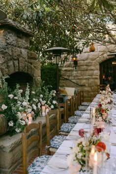 an outdoor dining area with tables and chairs set up for a formal meal, surrounded by greenery