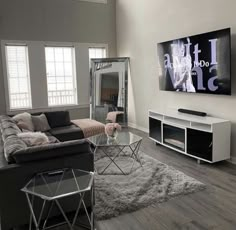 a living room filled with furniture and a flat screen tv mounted to the side of a wall