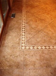 a bathroom floor with a tile border on it