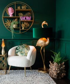 a living room with green walls and gold accents, flamingos are on the wall