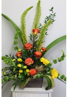 an arrangement of flowers and greenery in a vase