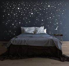 a bedroom with stars painted on the wall and a bed in front of it,