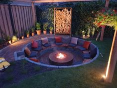 an outdoor fire pit surrounded by plants and lights