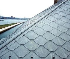 the roof of a building with water and buildings in the background