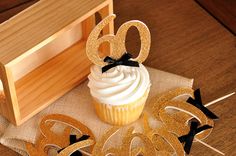 a cupcake sitting on top of a table next to a wooden box and sign