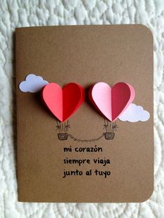 two heart shaped hot air balloons on top of a piece of brown paper that says mi corano siempre via jurto al tupo