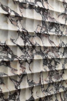 a close up view of marble tiles on the outside of a building in an urban area