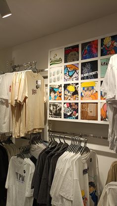 there are many t - shirts hanging on the rack in this store, and one is white