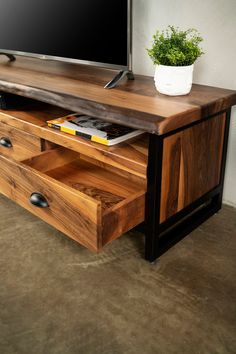 a wooden entertainment center with drawers and a flat screen tv