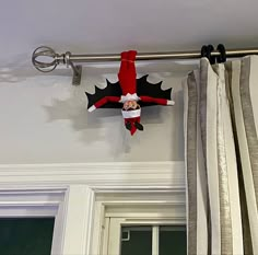 the elf is hanging on the curtain rod