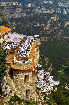 umbrellas are set up on the roof of an old castle like building in the mountains