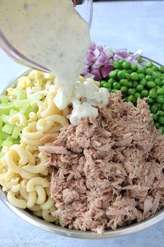 a bowl filled with pasta, meat and vegetables being poured into the bowl to make an appetizer