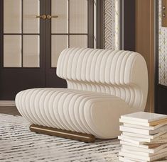 a white chair sitting on top of a rug next to a stack of books in front of a door