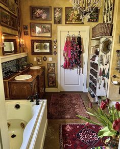 a bath tub sitting under a chandelier next to a sink in a bathroom