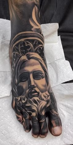 a man's hand with a tattoo on it and a jesus face in the middle