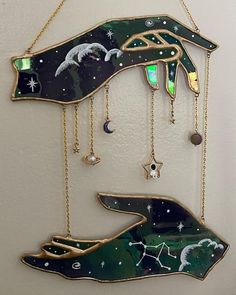 a wall hanging with two hands holding stars and moon in the night sky on it