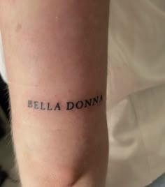 a woman's arm with the word bella donna tattooed on it in black ink