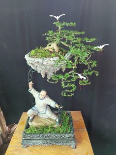 a bonsai figurine is displayed on a table