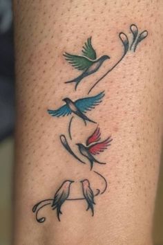 a tattoo on the leg of a woman with two birds flying above it and one bird sitting