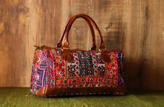 a multicolored bag sitting on top of a wooden table next to a wall