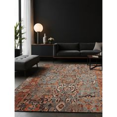 a living room with black walls and an orange area rug on the floor next to a couch