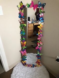 there is a mirror that has butterflies on it in the shape of a butterfly frame