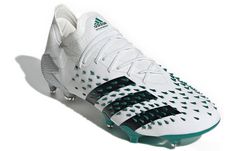 a white and green soccer shoe on a white background