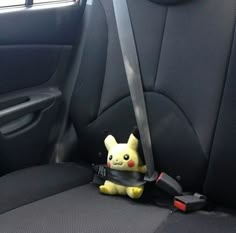 a stuffed pikachu sits in the back seat of a car with its head down