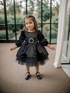 ✿ABOUT THIS DRESS ✓Our handmade elegant dress features a tutu that provides a playful and fluffy touch to the underskirt, while the 100% cotton lining ensures children's comfort. ✓It also features a pearl buckle bow on the front and black feather details on the shoulders. ✓The satin fabric adds a touch of sophistication, making this dress suitable for various occasions. ✿FABRIC INFORMATION ✓ Natural cotton lining 100% underskirt, tulle, satin on top. ✓ The color of your item may vary slightly fr Black Princess Dress For Spring, Black Princess Style Spring Dress, Black Princess Tutu Dress With Ruffles, Black Tulle Dress For Dress-up, Black Dress With Tulle Skirt For Dress-up, Satin Noir, Black Satin Dress, Black Feathers, Dress Long Sleeve