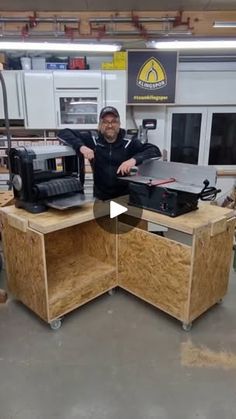 a man standing next to a work bench in a shop