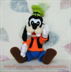 a crocheted mickey mouse with a green leaf on his head