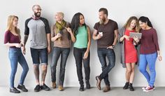 a group of young people standing next to each other in front of a white wall