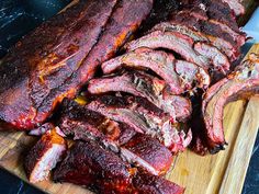 sliced up meat sitting on top of a wooden cutting board