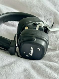 a pair of headphones laying on top of a white blanket