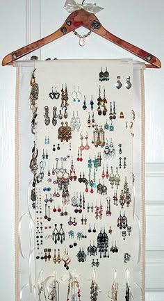 a white wall hanging with lots of earrings on it