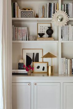 a white bookcase filled with lots of books