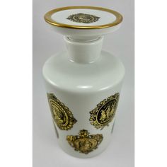 a white vase with gold trimmings on the top and bottom, sitting in front of a white background