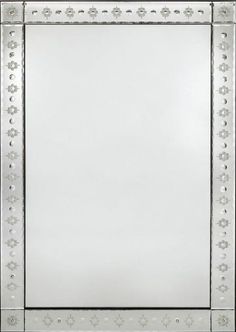 an ornate silver framed mirror with flowers on the border and beading around the edges