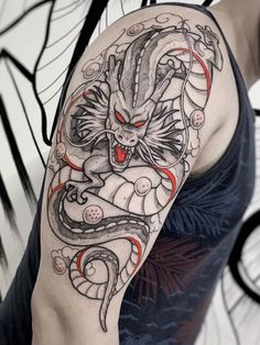 a man with a dragon tattoo on his arm and shoulder is shown in black and grey